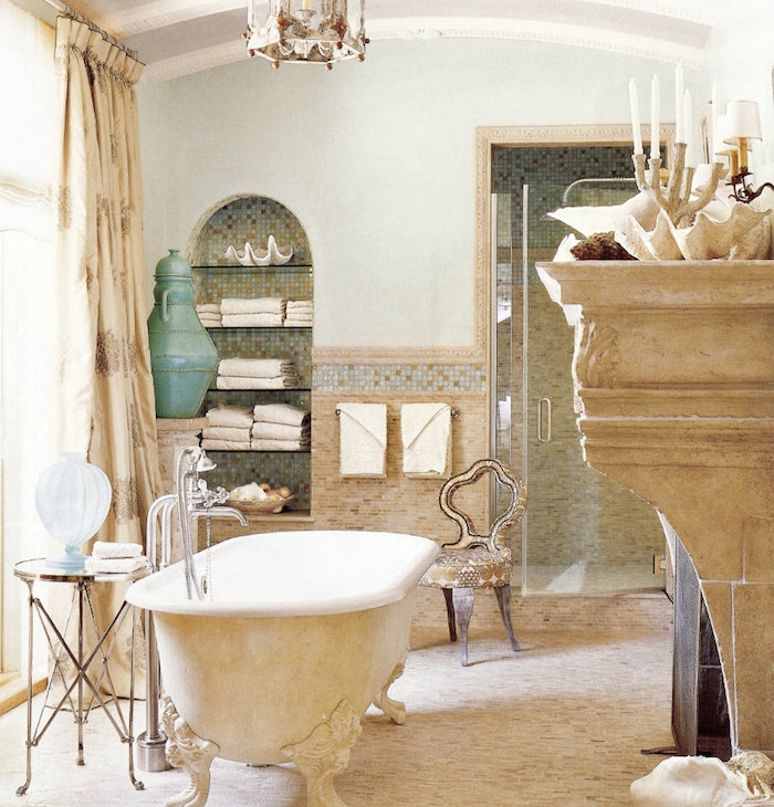 baignoire beige et blanc sur pieds, sol beige, cheminée décorative, niche murale rangement, chaise design vintage campagne