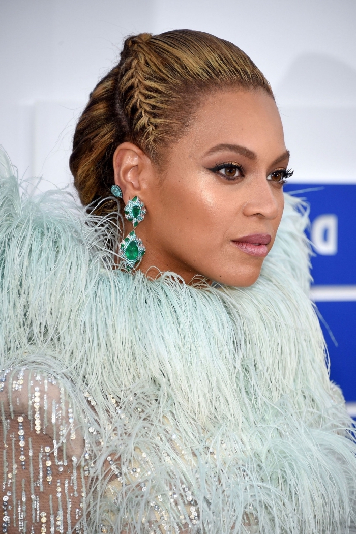 coiffure moderne et originale de Beyonce aux cheveux longs attachés en chignon avec une couronne de petite tresse plaquée, tresse sur le côté