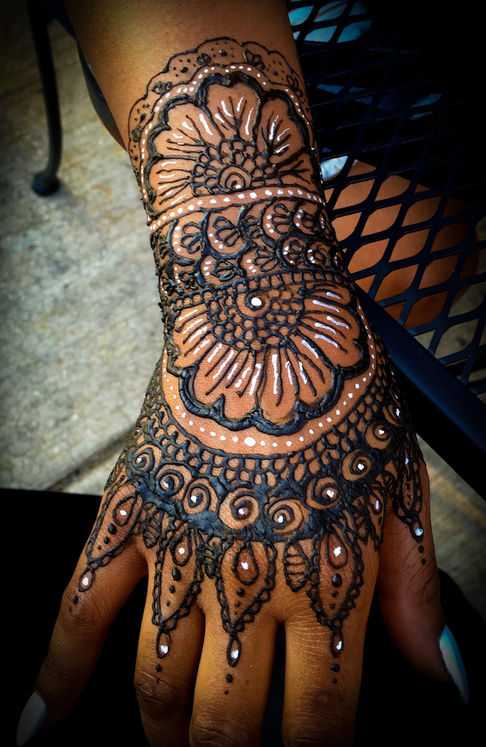 illustration au henné blanc et noir sur la main et le poignet femme
