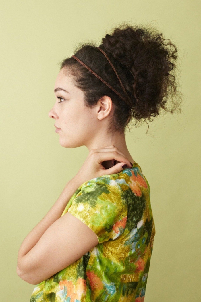 modèle de coiffure simple avec un élastique autour de cheveux attachés en chignon haut décontracté pour cheveux crépus