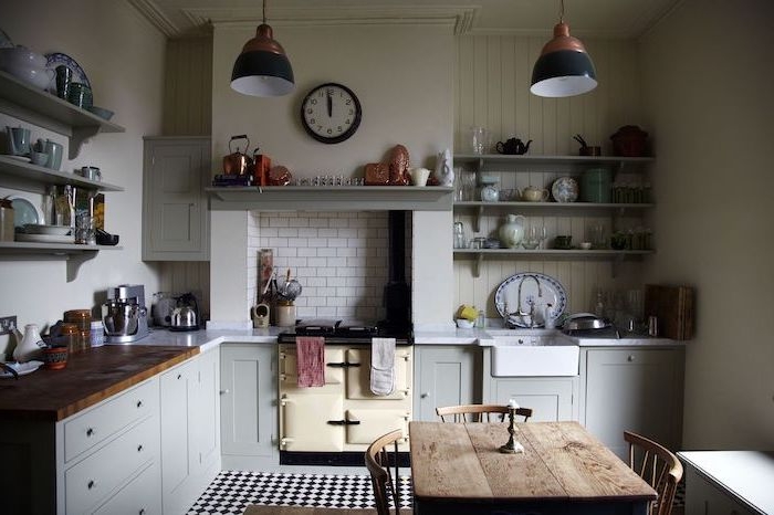 exemple de cuisine campagne chic avec meuble bas gris, plan de travail bois, table et chaises bois, brut, étagères ouvertes grises, vaisselle vintage