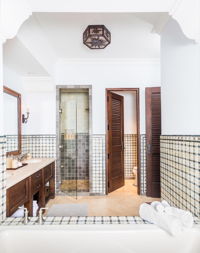 une salle de bain carreaux de ciment de style espagnole posés en guise de soubassement qui s'accorde parfaitement avec l'aspect antique du meuble salle de bains