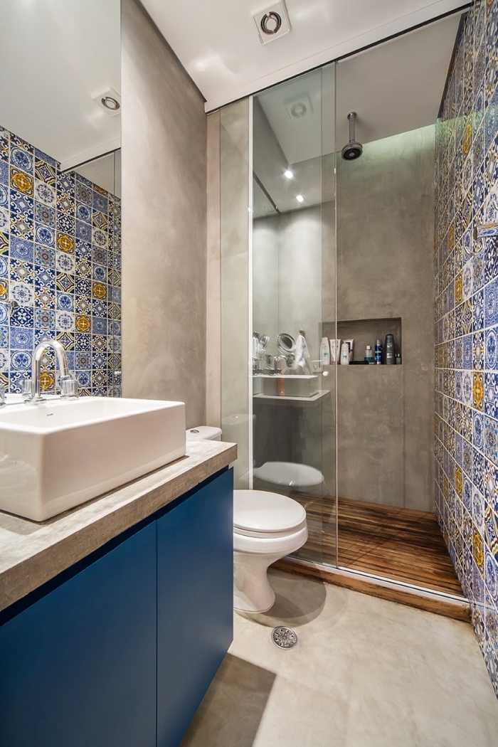 une salle de bains à l'italienne qui joue sur le contraste de l'aspect béton avec le carrelage effet carreaux de ciment à motif patchwork