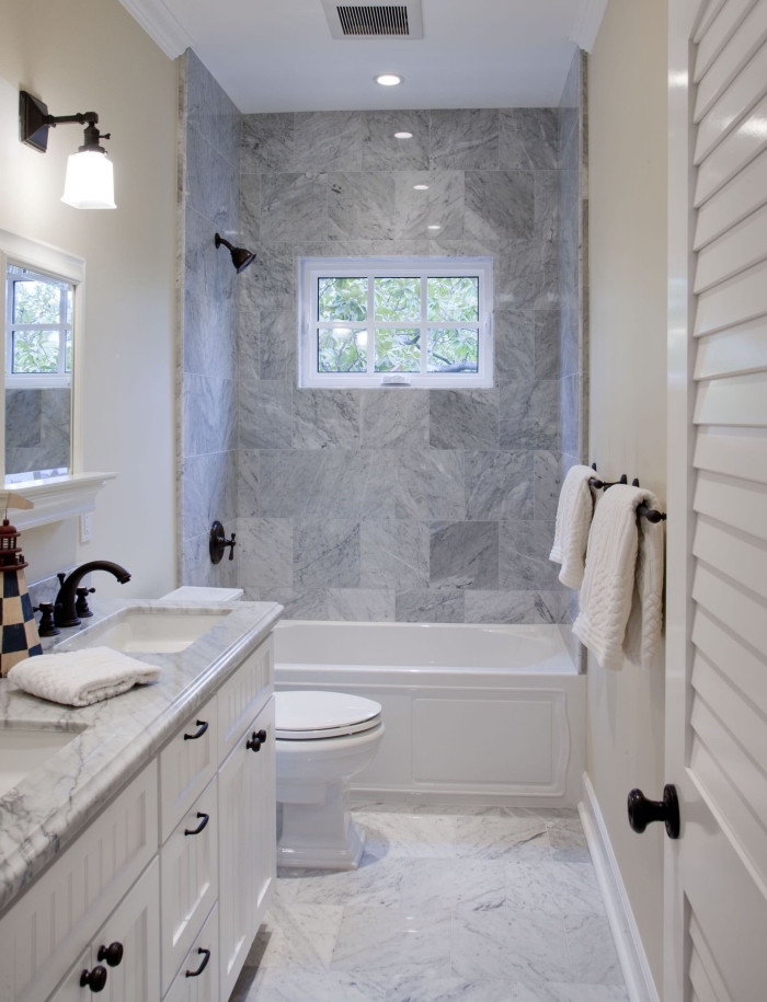 aménagement petite salle de bain avec baignoire, design intérieur stylé avec carrelage marbré et peinture murale beige