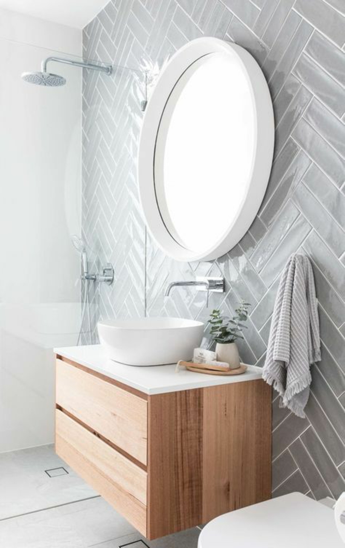 salle de bain 4m2, murs en couleur gris perle, miroir rond au cadre blanc, douche italienne en petit espace, meuble suspendu en beige