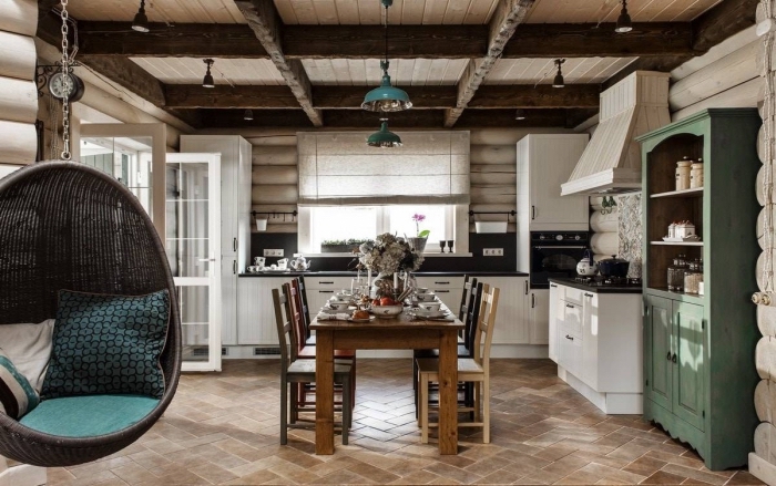 déco cocooning dans une cuisine traditionnelle aux murs en bois avec plafond en poutres de bois apparentes et carrelage de sol beige