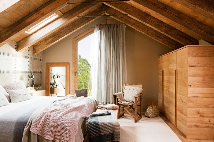 modèle de chambre rustique sous plafond avec poutres exposées et meubles de bois, idée comment aménager une pièce mansardée