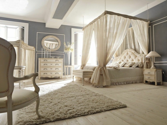 chambre spacieuse en couleur crème, chaise baroque, commode en bois, miroir ovale, lit baldaquin, deco romantique