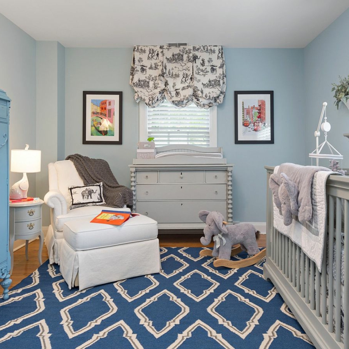 tapis bleu géométrique, fauteuil blanc, jouet éléphant, cadres peintures, commode gris clair