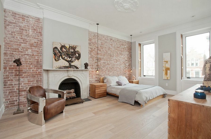 chambre spacieuse, mur en briques, fauteuil en cuir, cheminée décorative, ampoules suspendues, deco chambre romantique