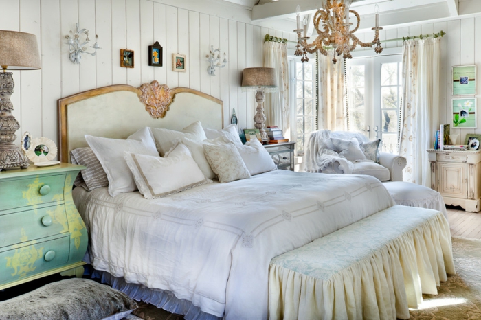 décoration chambre adulte moderne, chandelier somptueux, tête de lit blanc et doré, commode vert menthe, parement mural planches blanches