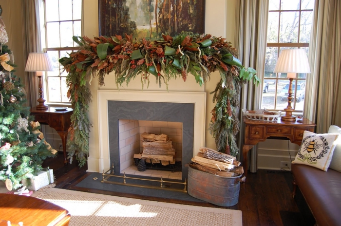 cheminée décorative en style traditionnel, déco de noel avec verdure, deux consoles en bois