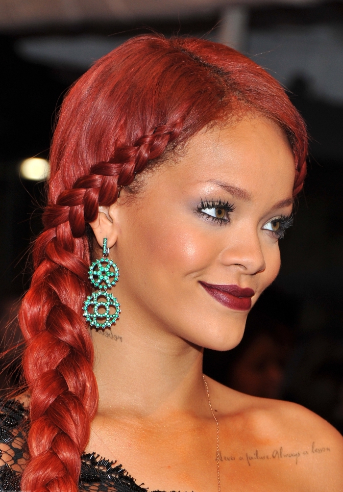 coiffure de Rihanna aux cheveux longs rouges attachés de côté, exemple de coiffure avec tresse africaine sur le coté