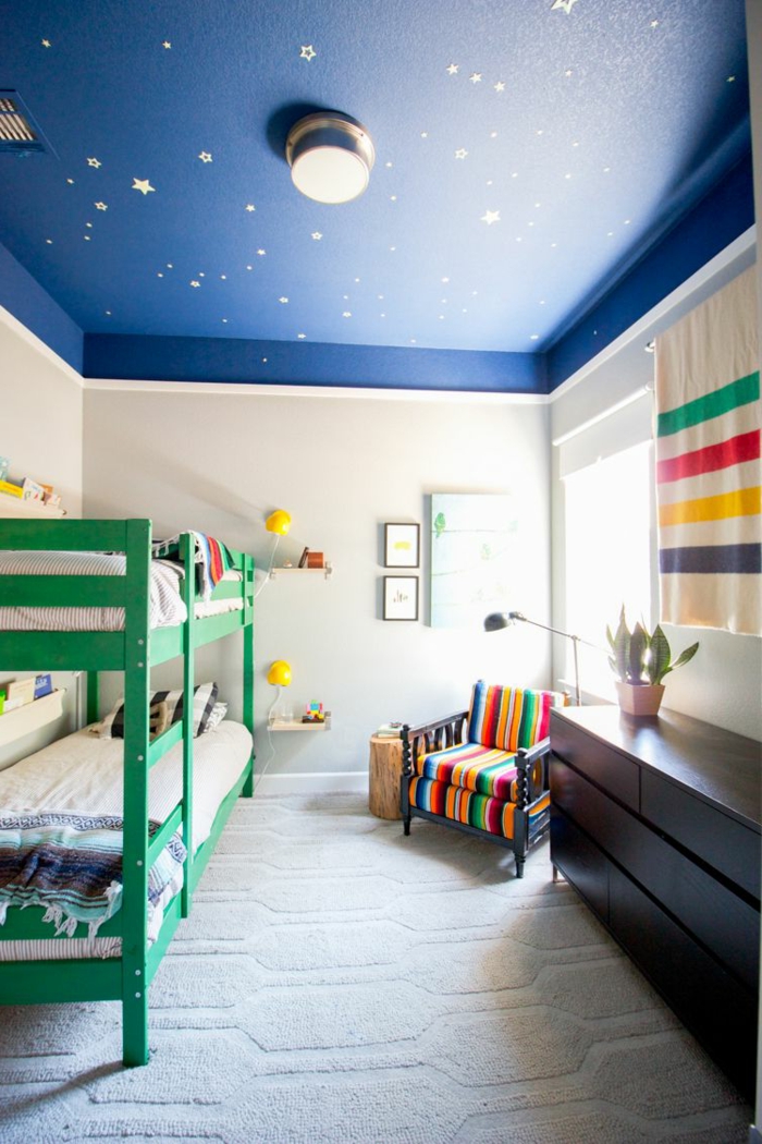 plafond bleu aux étoiles dans une chambre enfant garcon, lits mezzanine verts, fauteuil bariolé