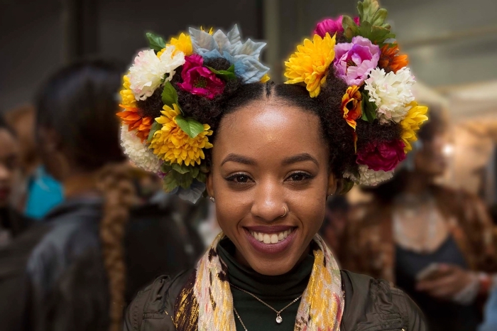 cheveux frisés femme, exemple de coiffure sur cheveux crépus attachés en deux couettes hautes ornées de couronnes florales