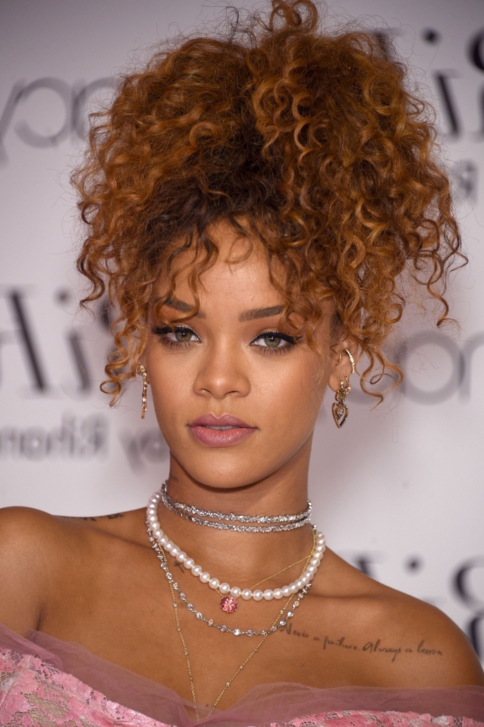 Rihanna aux cheveux longs de couleur châtain cuivré attachés en queue de cheval haute avec mèches tombantes sur le visage