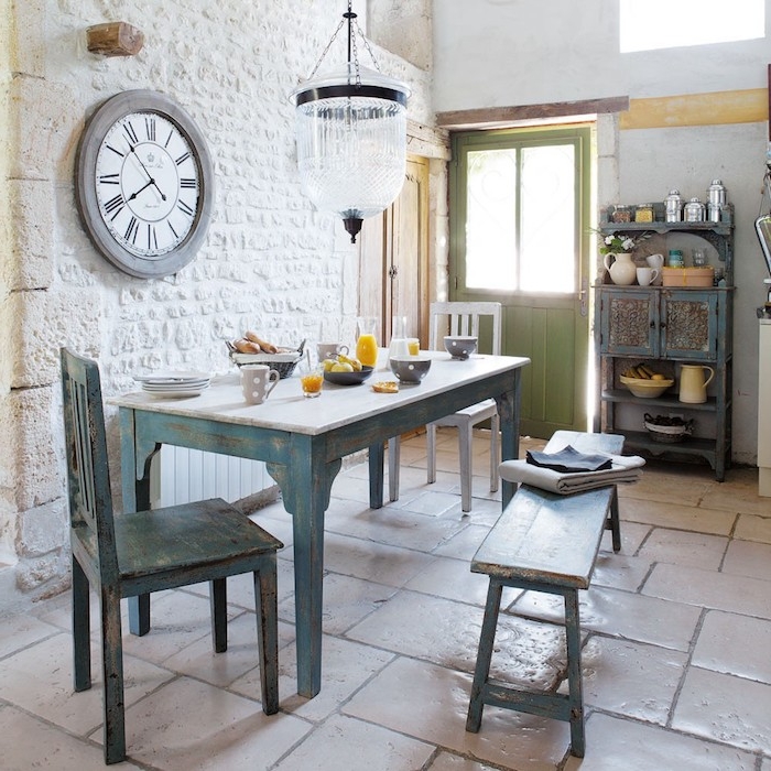 mur de briques blanches, table, chaise et bancs en bois brut couleur bleue, carrelage sol retro, vaisselier vintage, deco anglaise de campagne