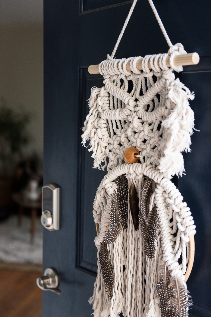 objet DIY réalisé avec la technique noeuds macramé et décoré avec plumes et perles de bois, déco de porte avec création macramé