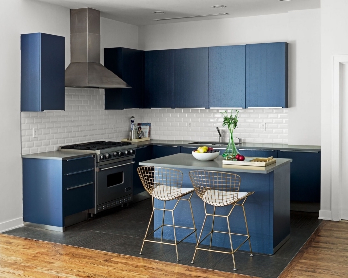 exemple d'aménagement d'une petite cuisine avec ilot qui en bleu et acier qui s'accorde avec les couleurs et les matières utilisées pour les armoires