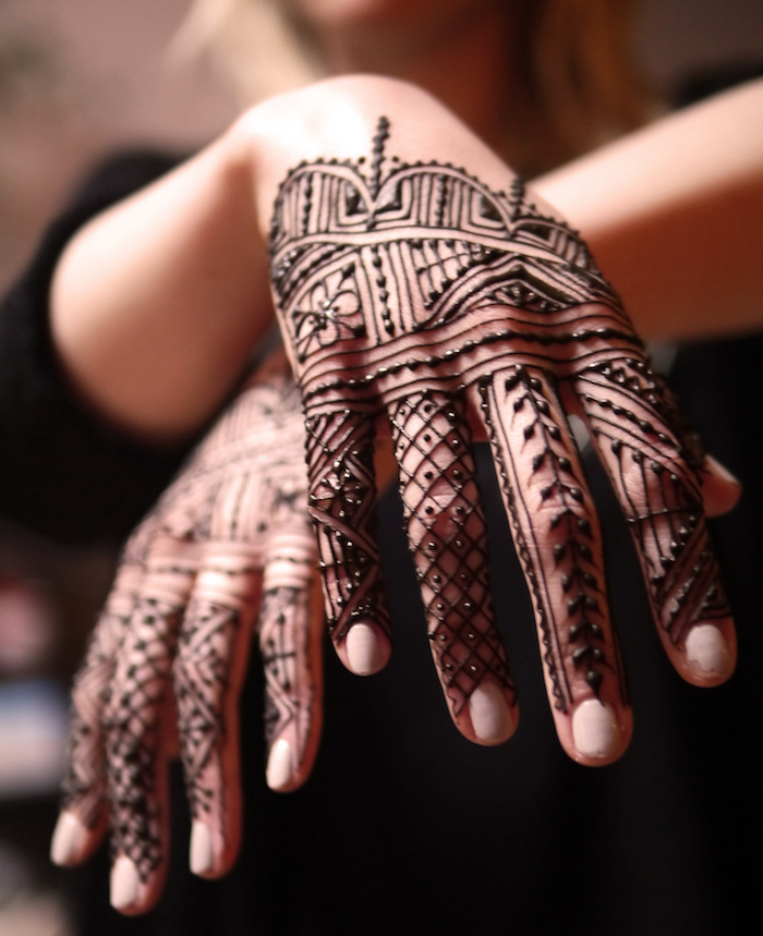 mains recouvertes de henné avec motif style dentelles lignes fines et détaillées