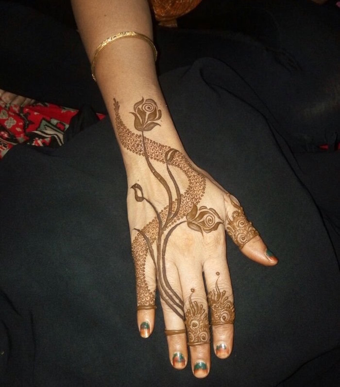 modèle dessin au henné marron avec fleurs roses sur main et poignet