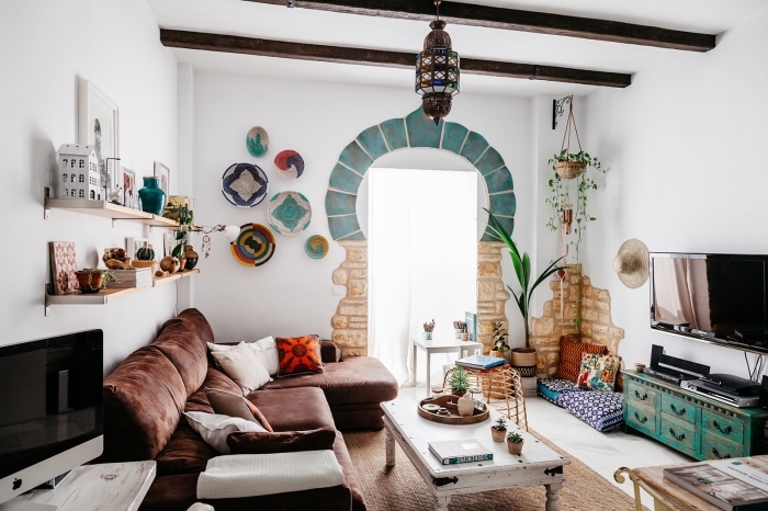 ambiance exotique avec objets décoratifs de style ethnique chic dans un salon blanc avec poutres de bois foncé sur le plafond