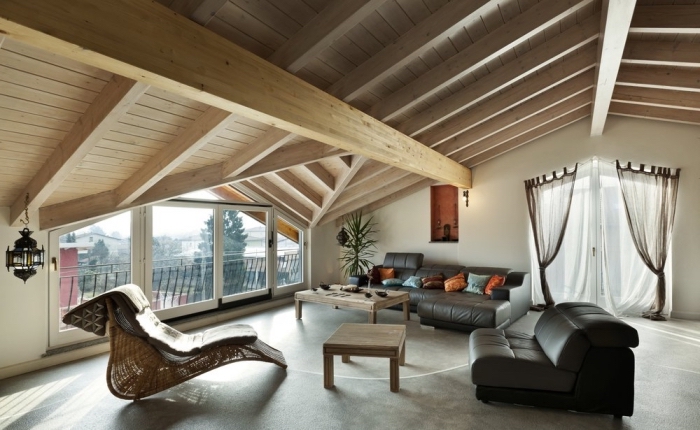 design intérieur de style moderne dans une pièce mansardée aux murs blancs avec joli plafond en poutres de bois clair