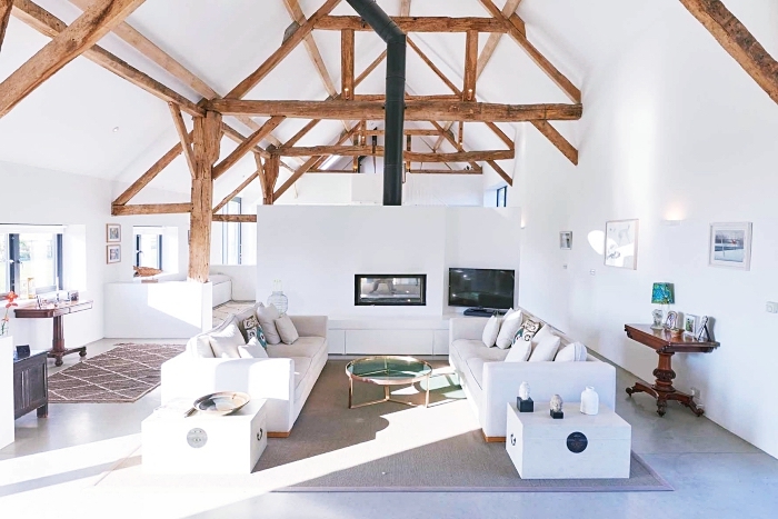exemple aménagement studio chaleureux en blanc avec poutres de bois sur les murs et le plafond, idée déco salon cozy