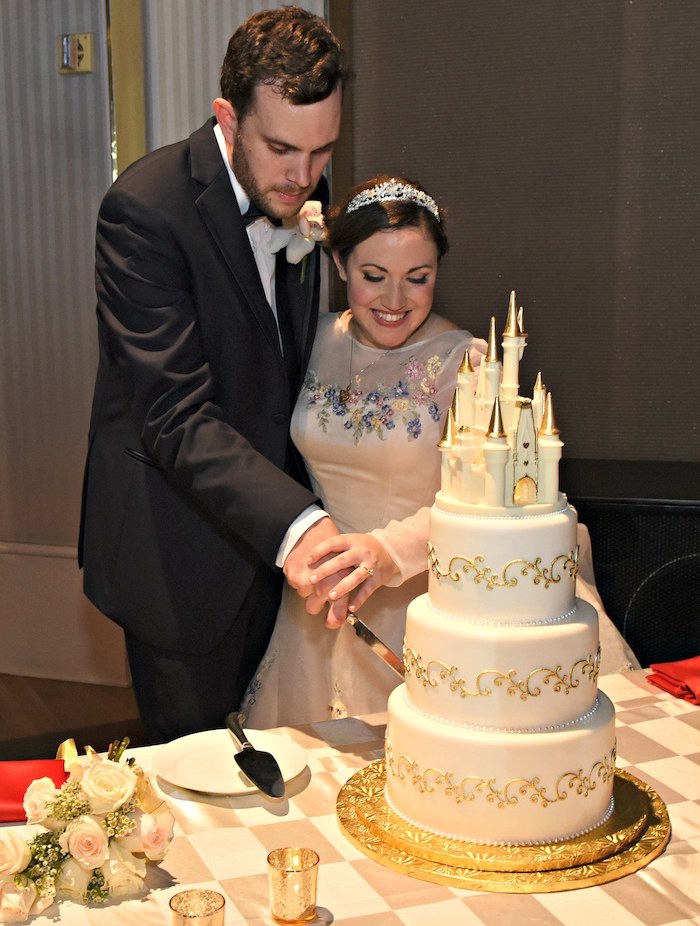 Image de gateau wedding cake château, mariage sujet Disney chateau magnifique, gateau mariage simple blanc et doré, les mariés qui coupent un morceau