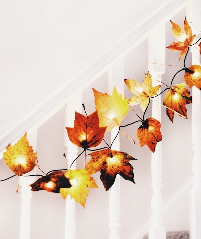 idée de deco montée escalier blanc avec des feuilles mortes accrochées sur guirlande lumineuse