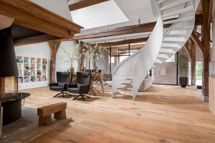 design intérieur de style contemporain dans une maison spacieuse au parquet de bois et murs blancs avec charpente apparente