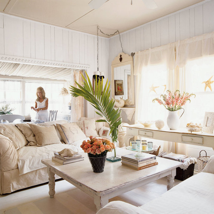 canapé beige, table basse bois patiné, canapé blanc, console decorative blanche, bouquet de fleurs, mur lambris blanc