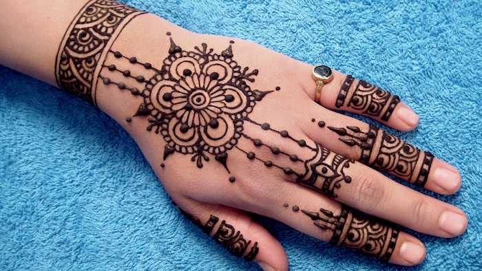 exemple de motif henné simple sur la main et les doigts de femme