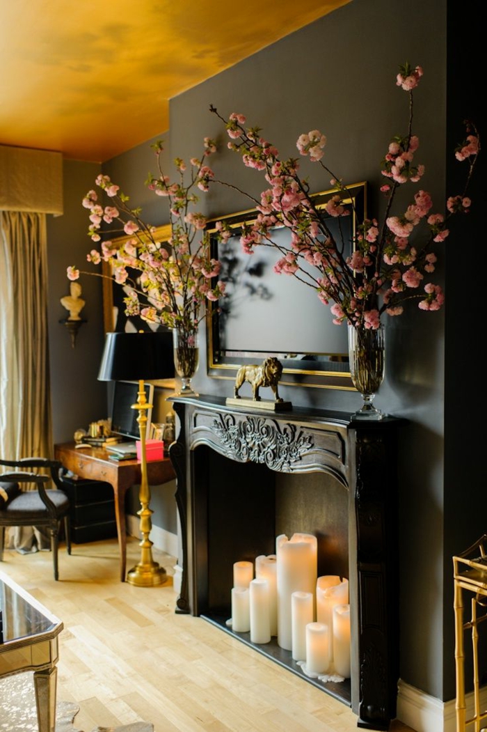 cheminée décorative noire, statuette lion, fleurs en vases, plafond jaune, meubles style baroque