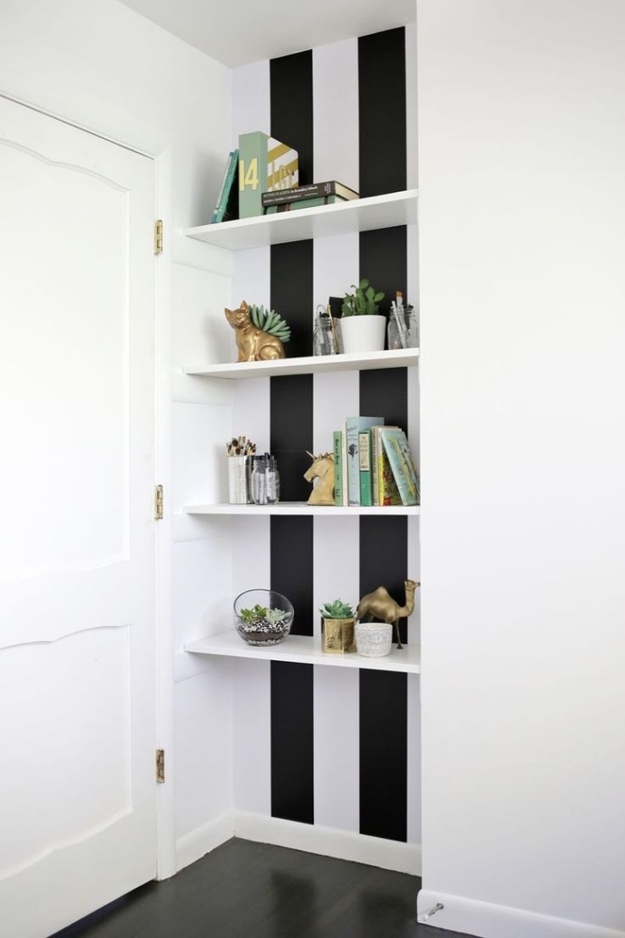 pose papier peint adhésif à rayures noir et blanc derrière une étagère ouverte pour créer un joli recoin déco en contraste avec les murs blancs
