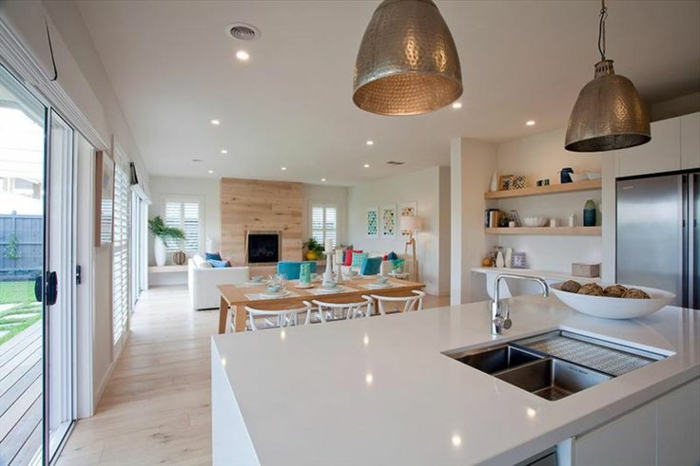 jolie idée cuisine ouverte, lampes loft, grand comptoir blanc avec évier, rayons muraux en bois
