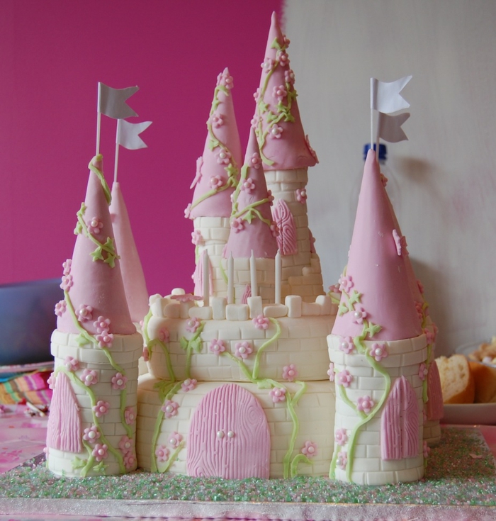 gateau piece montee, chateau en blanc et rose avec plusieurs tours couvertes de pâte à modeler