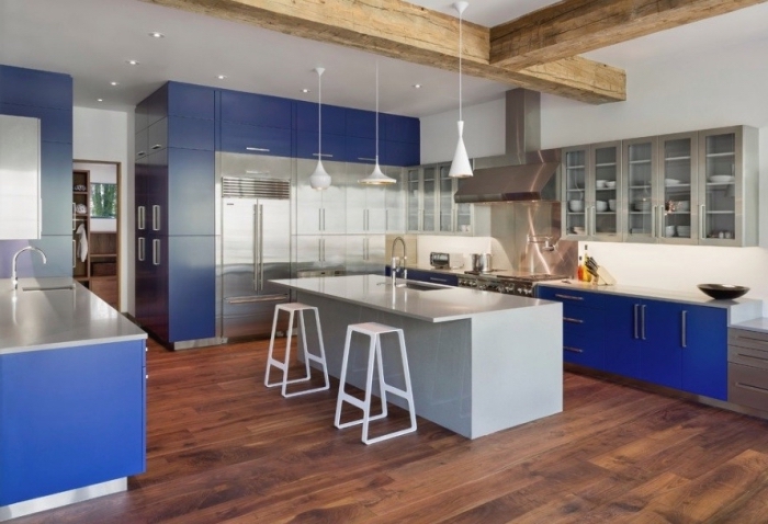 cuisine gris et bleu au design contemporaine avec un ilot de cuisine gris à finition lisse qui joue le rôle d'un coin repas convivial