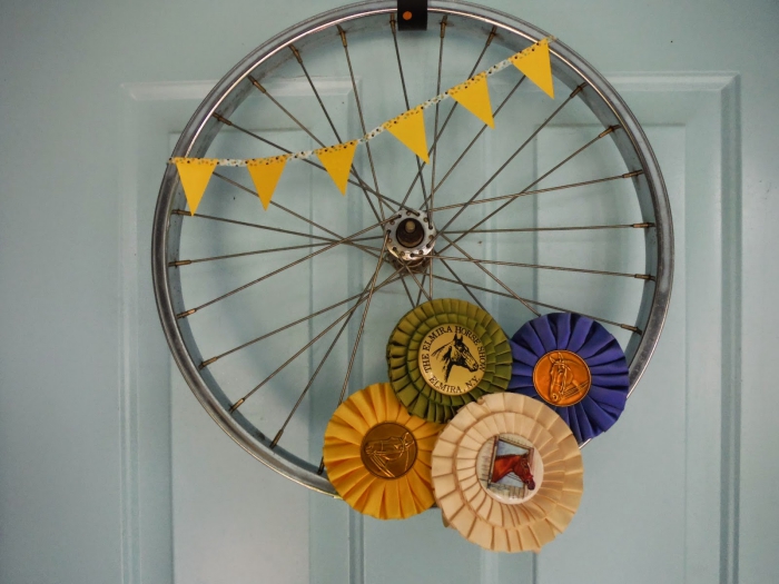 décoration de porte originale avec un objet détourné, roue de vélo recyclée en jolie couronne de porte d'esprit récup
