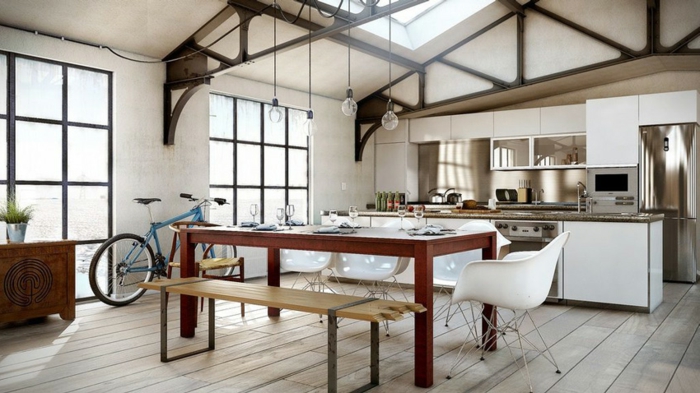 espace style loft industriel, sol en bois, peinture blanche, table de repas en bois, équipement de cuisine blanc