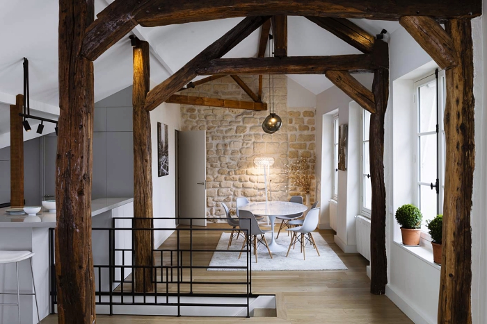 design intérieur moderne et traditionnel dans un petit studio avec revêtement mural en pierre et charpente de bois brut apparente