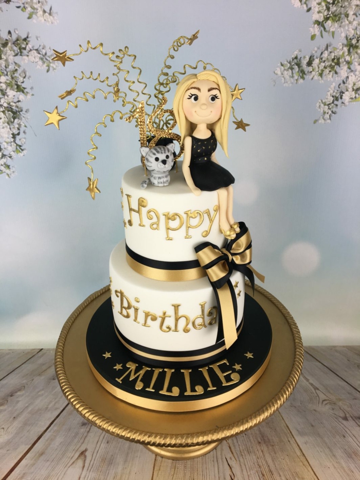 gateau anniversaire fille en noir et blanc, chat et fille qui s'est assise au top du cake