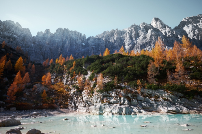 lac bleu sous une colline rocheuse, pins et sommets rocheux, paysage pour fond d'écran