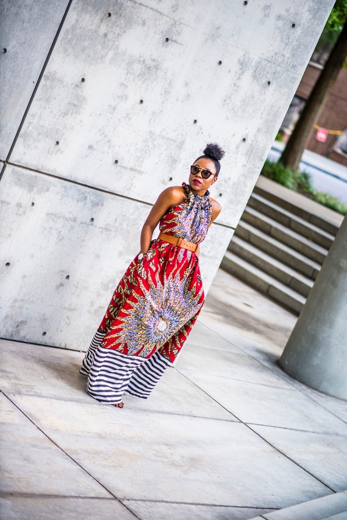 tenue africaine pour la femme moderne, robe longue et fluide à motif africain gros soleil, avec des rayures sur le bas portée avec ceinture à la taille