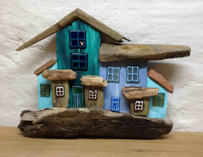 maison peinte bleue avec bois flotté, plusieurs toitures an bois flotté