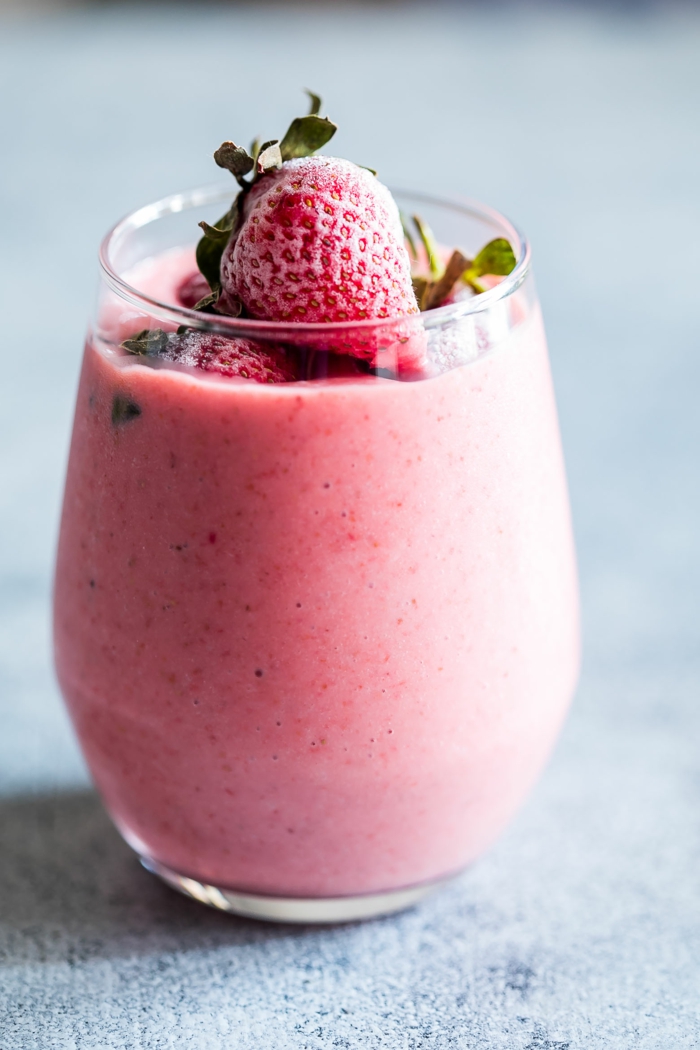 milkshake lait et fraises congelées, topping fraises, petit verre plein d'un liquide crémeux et rose
