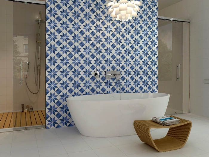 des carreaux de ciment salle de bain posés derrière la baignoire qui réveillent l'ambiance épurée avec leurs motifs marguerites bleues rétro