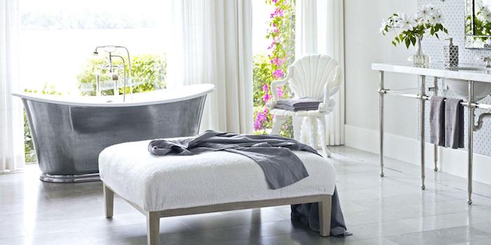 idée de baignoire en fonte grise dans une salle de bain style campagne, chaise blanche, tabouret gris et blanc, lavabo console