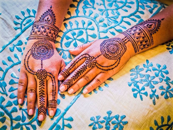 dessins symétriques au henné sur les mains et poignets de femme 