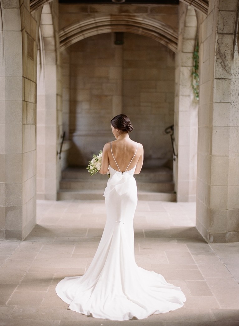 robe de mariée fourreau élégante et féminine avec un décolleté dos mis en valeur par deux fines bretelles et un noeud romantique à la taille